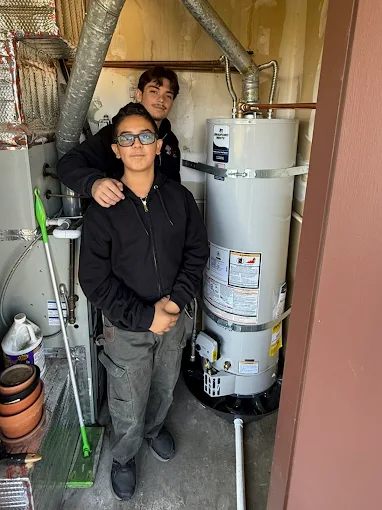 Alberto's two kids standing by a newly installed Premier Plumbing Solutions 925 water heater